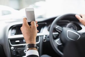 Businessman sending a text message | The Persistent Problem of Distracted Driving Continues