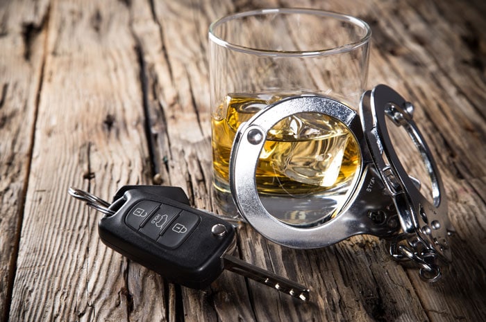 glass of whiskey with car keys and handcuffs on a table | Drunk Driving Accidents