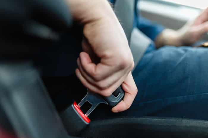 person buckling their seatbelt