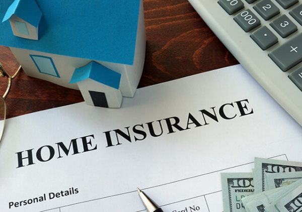 home insurance document on a desk with a keyboard a small house and money
