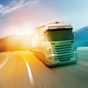trucking driving down highway at sunrise | Defective Tire Trucking Accidents