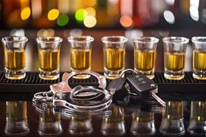 row of shots on a bar with car keys and handcuffs | Colorado Dram Shop Laws