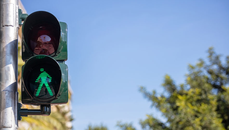 green walk light against a blue sky | Colorado Springs Pedestrian Accident Attorneys