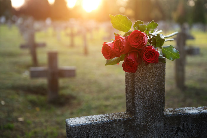 cemetery with roses on a tombstone | Colorado Springs Wrongful Death Attorneys