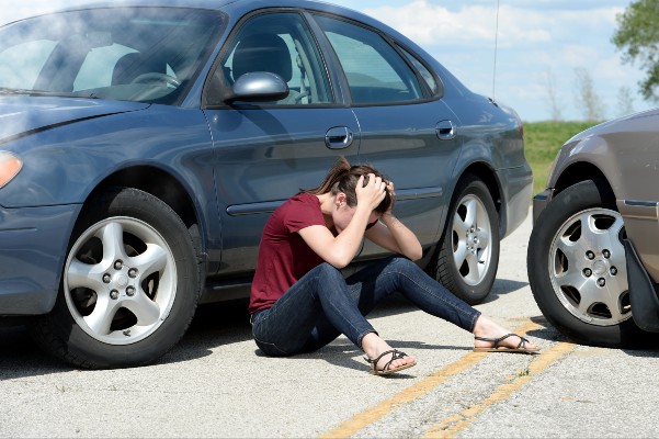 upset woman head in hands after accident | Factors Leading to Accident Fatalities